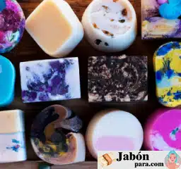Collage de jabones artesanales en variedad de colores y formas, presentados sobre una superficie de madera rústica.