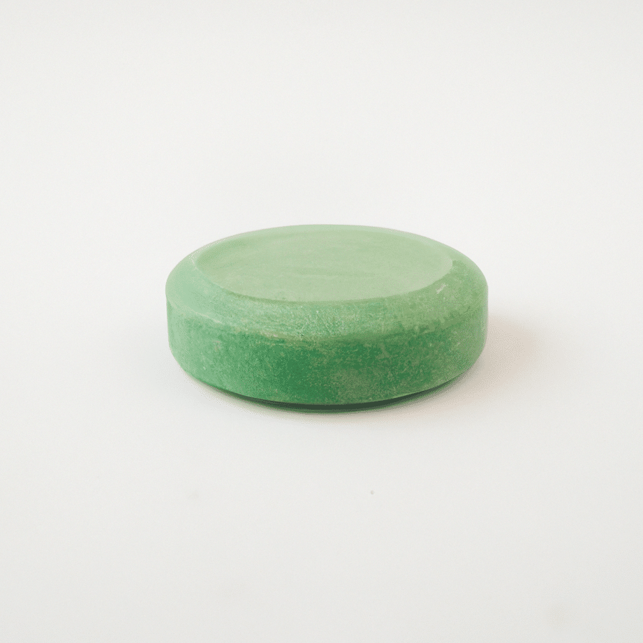 una-foto-de-una-pastilla-de-jabon-de-arcilla-verde-en-un-fondo-blanco